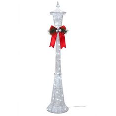 a tall white pole with a red bow on it