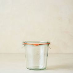 an empty glass jar with a red lid