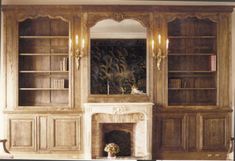 a living room filled with furniture and a fire place in front of a book shelf