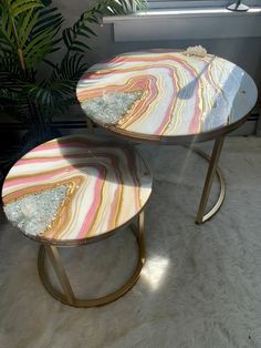 two marble tables sitting next to each other on a white rug in front of a window