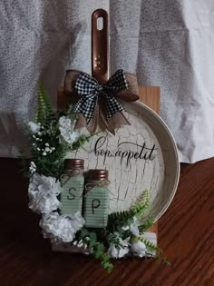 a wooden tray with some jars and flowers on it that says compoetat