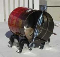 a large metal barrel sitting on top of a cement floor next to a building with windows