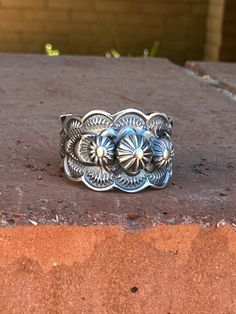 Enhance your western look with our Cassidy Sterling Flower Cigar Band Ring. Handcrafted with intricate floral details, this beautiful ring adds a touch of sophistication to any outfit. Show off your unique style and make a statement with this one-of-a-kind piece! Handmade Cigar Band Sterling Silver Navajo Horse Hair Pottery, Western Rings, Navajo Rings, Bridesmaid Gifts Jewelry, Twisted Band, Authentic Jewelry, Jewelry Lookbook, Beautiful Ring, Rock Star