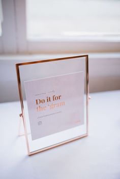 a white table with a gold frame on it that says do it for the gramm