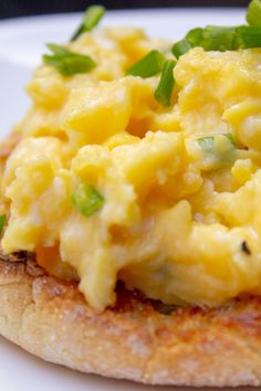 an omelet is sitting on top of a piece of bread with green garnish