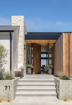 the entrance to a modern home with stone steps