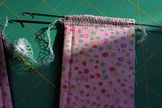 two pieces of fabric are being sewn together on a green surface with scissors and thread