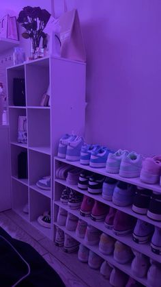 there are many pairs of shoes on the shelf next to each other in this room