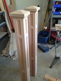 two tall wooden posts in the middle of a room with tools and other items around them