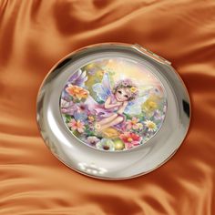 a plate with a fairy sitting on it's side in front of a satin background