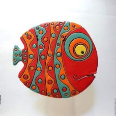 a red and blue fish with yellow eyes on it's face is standing in front of a white wall