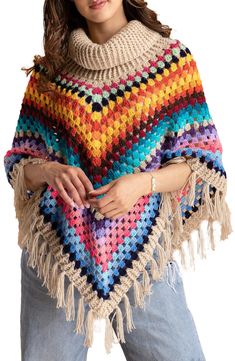 a woman wearing a multicolored crocheted ponchy with fringes