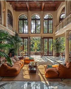 a large living room with high ceilings and lots of windows on the ceiling, along with two couches