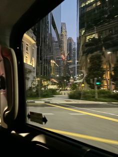 the view from inside a car looking at skyscrapers and buildings in the city center