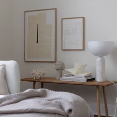 a bedroom with white furniture and art on the wall