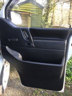 the door handle is open on a car that's parked in front of a house