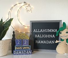 a stuffed animal next to a sign and potted plant on a table with lights