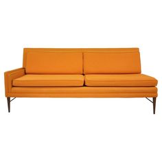 an orange couch sitting on top of a white floor