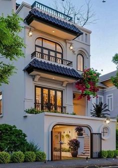 a large white house with lots of windows and balconies on the second floor