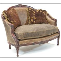 an old fashioned chair with brown and gold pillows on it's armrests