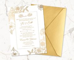 an elegant wedding card with gold foil and flowers on the front, in arabic script