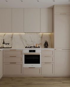 a kitchen with white cabinets and marble counter tops, along with a stove top oven