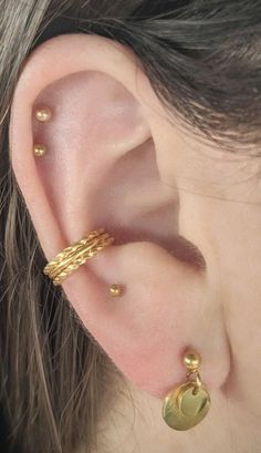 a close up of a person's ear with two gold rings on top of it