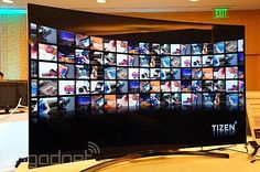 a large television screen with many different images on it's side and people in the background