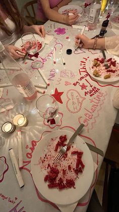 two women sitting at a table with plates and utensils in front of them