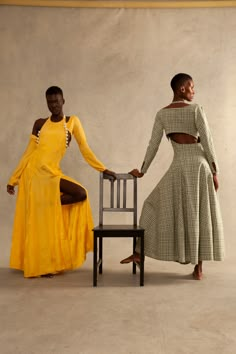 two women standing next to each other near a chair