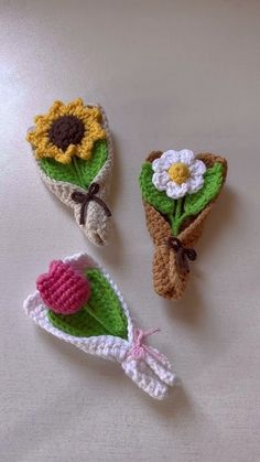 three crocheted flowers are placed next to each other