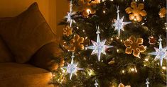 a christmas tree decorated with teddy bears and lights in the shape of snowflakes