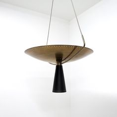 a black and gold light fixture hanging from a ceiling in a white room with no walls