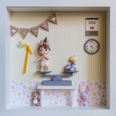 a shadow box with some toys in it and a clock on the wall next to it