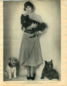 an old black and white photo of a woman holding two dogs in front of her