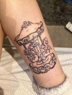 a woman's leg with a tattoo on it that has an image of a hat and boots