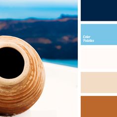 a brown vase sitting on top of a table next to a blue and white wall