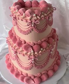 a three tiered cake with pink icing and ruffles