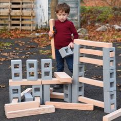 a young boy is playing with wooden blocks