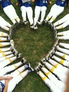 a group of baseball players standing in a heart shape