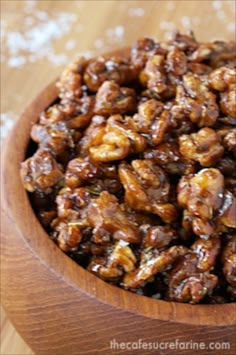 a wooden bowl filled with nuts on top of a table