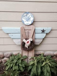 a wooden chair sitting in front of a house with flowers on it's back