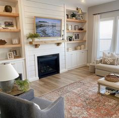 a living room filled with furniture and a flat screen tv mounted on the wall above a fire place