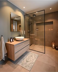 a bathroom with a sink, mirror and shower stall