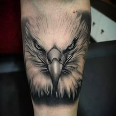 an eagle tattoo on the leg with black and grey ink, it looks like he is looking