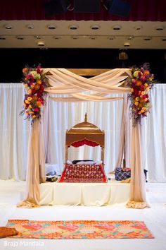 the bed is decorated with flowers and draping on it's headboard