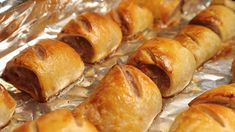 several pastries are sitting on tin foil and ready to be baked in the oven