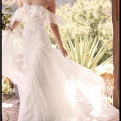 a woman in a wedding dress is posing for the camera with her hand on her hip