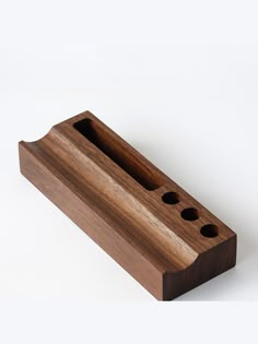 a wooden object with holes in it on a white surface