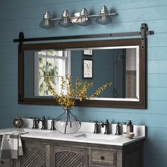 a bathroom vanity with two sinks and a large mirror above it in front of a blue wall